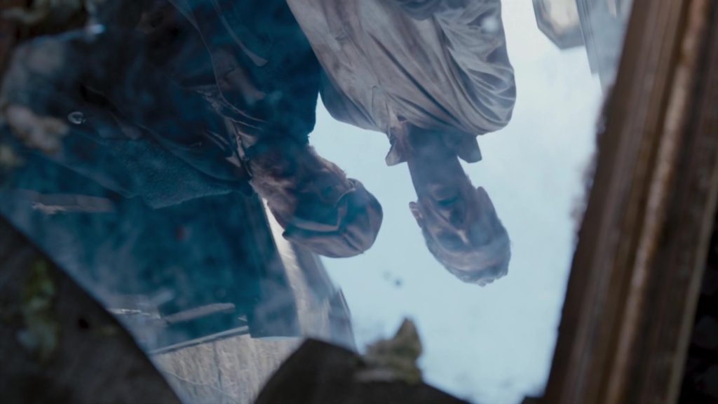 12th doctor peter capaldi staring at a reflection of himself, seemingly confused.